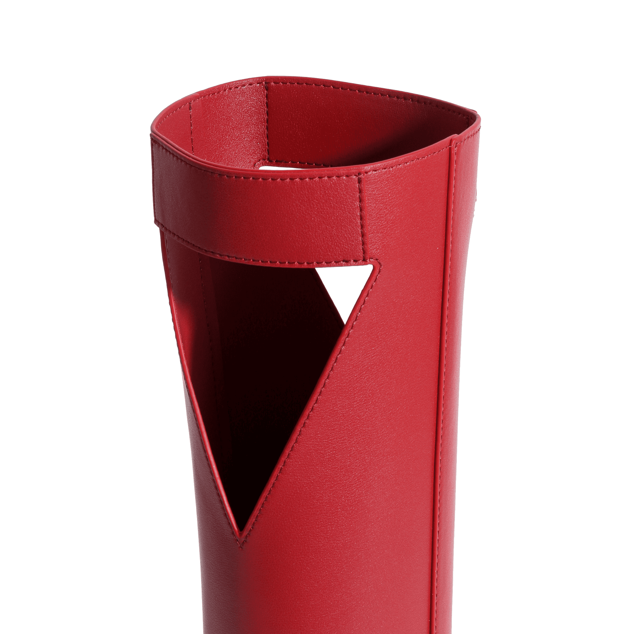 Close-up of the upper part of a red, full-grain leather boot with a unique triangular cutout design and visible stitching along the top edge, reminiscent of premium leather wine carrier craftsmanship.