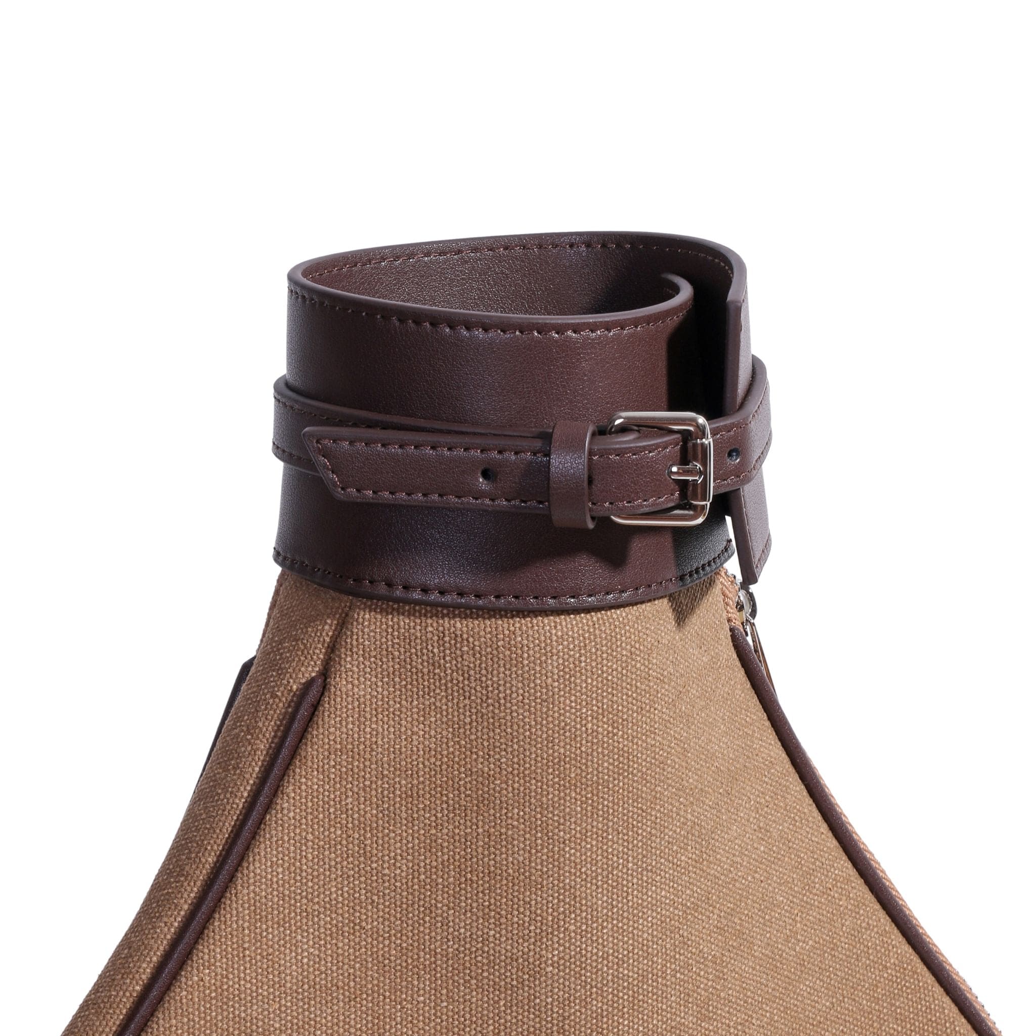A close-up of a brown leather buckle strap wrapped around the neck of a beige textured fabric, possibly part of a luxury leather tennis bag or an elegant canvas tennis bag detail.