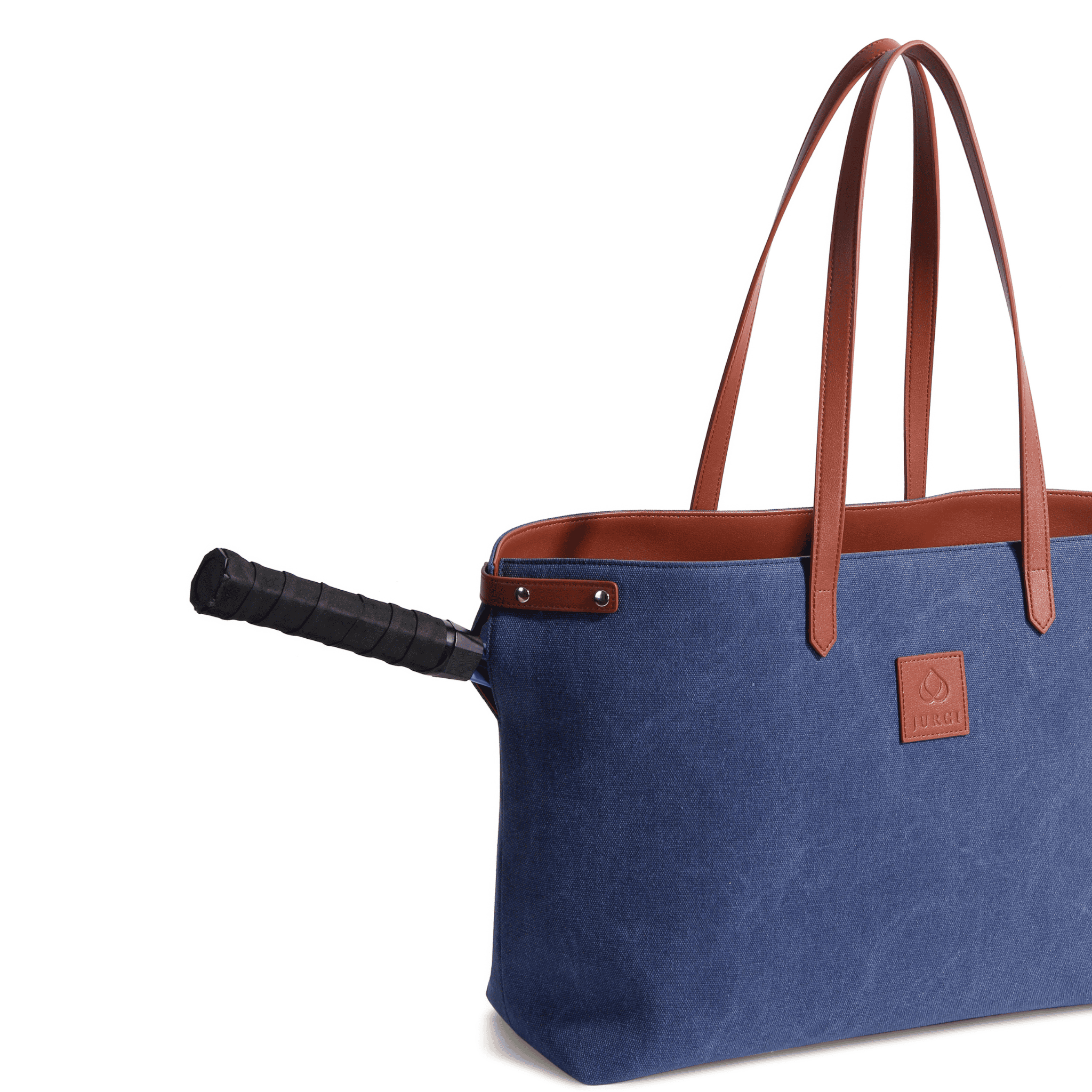 A blue and brown canvas leather court bag with long handles, designed as a tennis racket tote, features a racket handle sticking out from a side pocket.