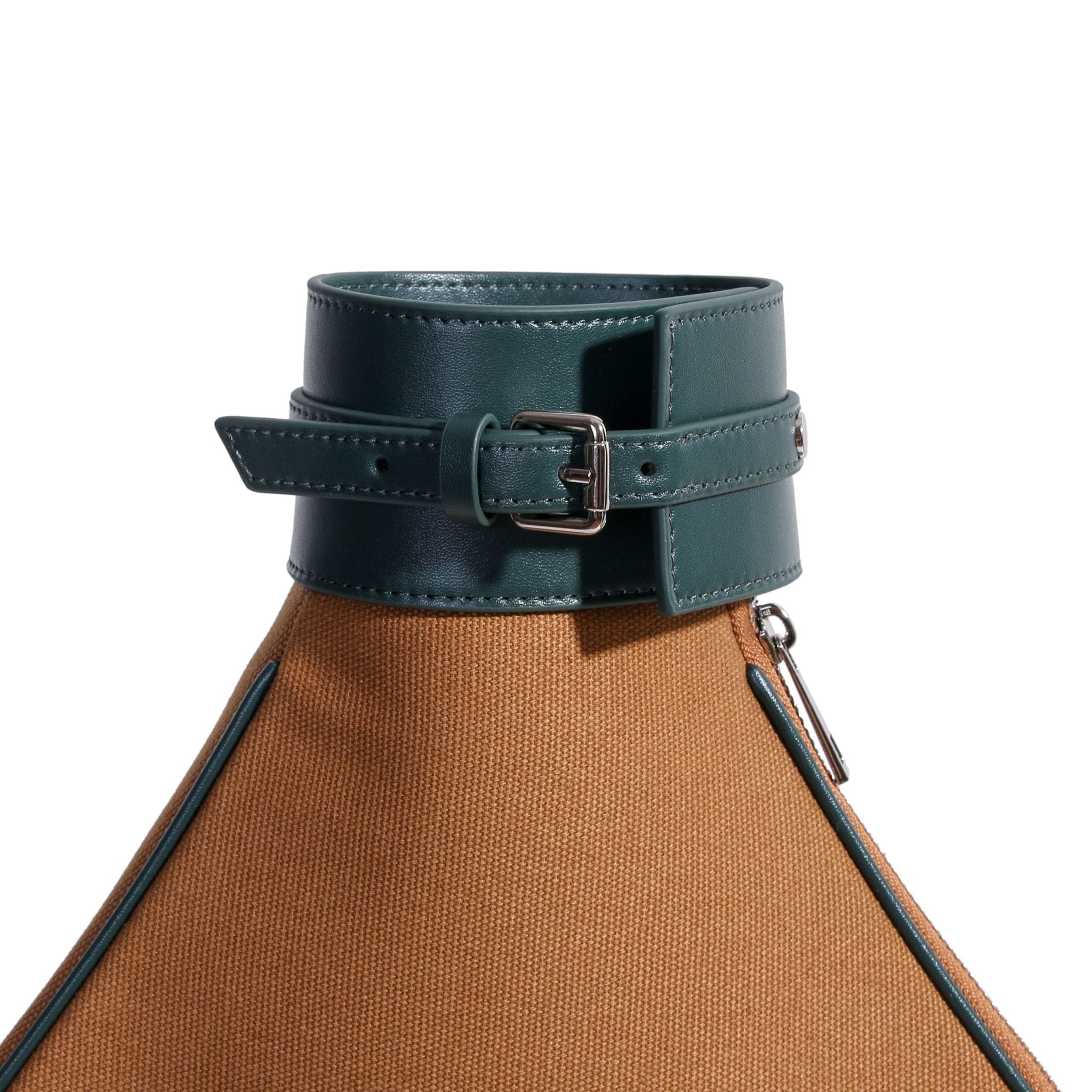 A close-up of a tan canvas tennis bag with green leather trim and a matching green leather strap and buckle detail near the top. The bag also features a silver zipper pull on the side.