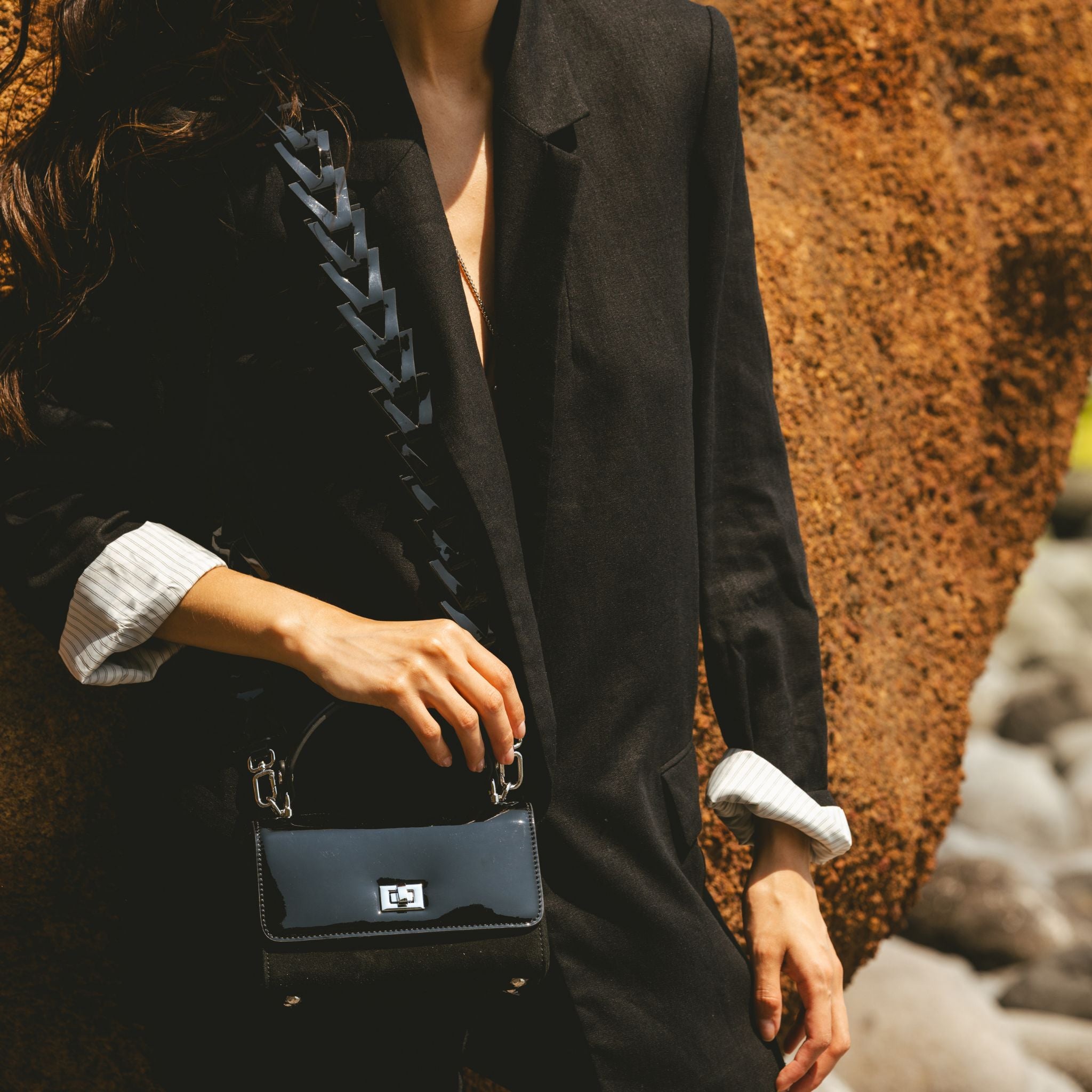 Black jacket styling with a black patent handbag and a triangle strap