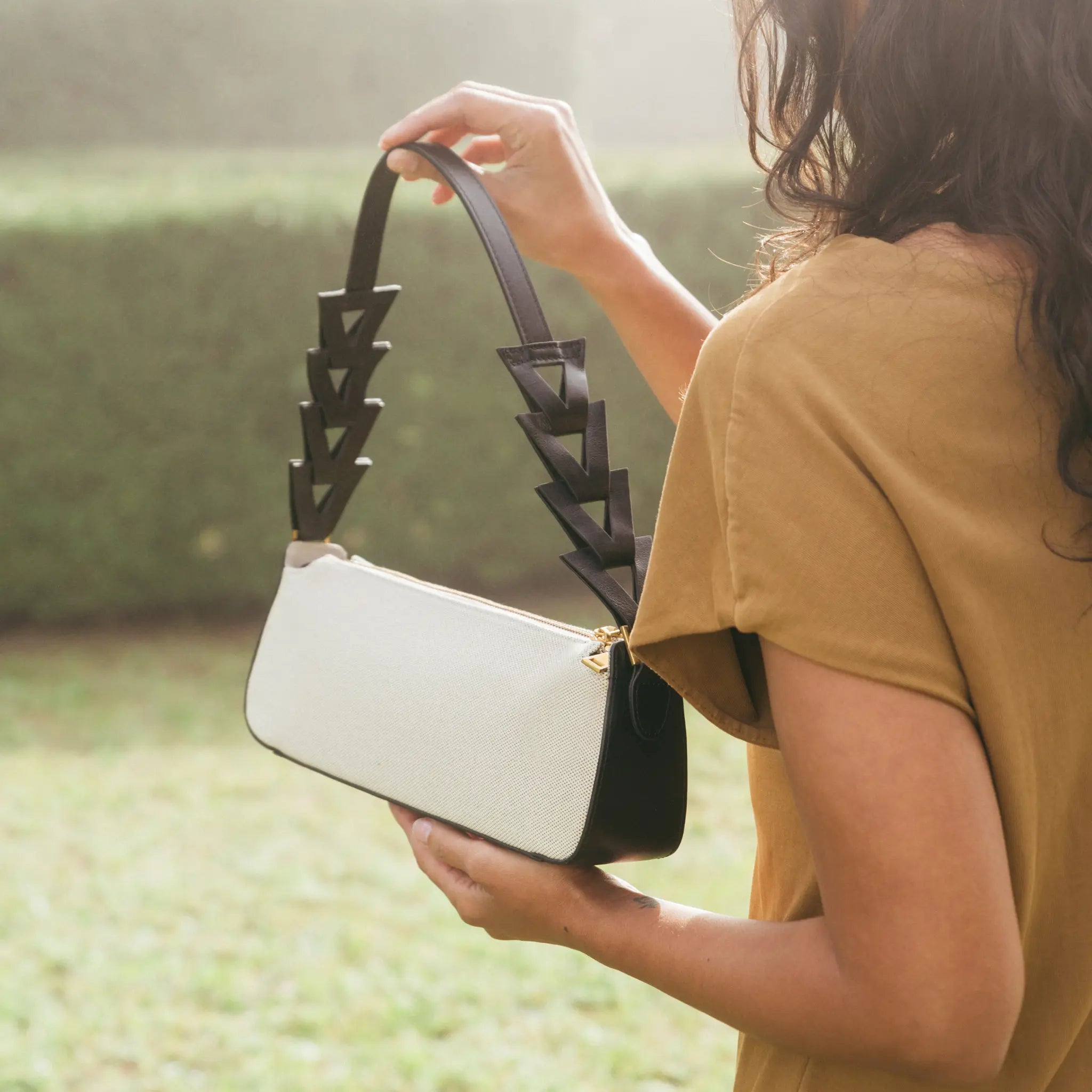 Model is holding Canvas and black leather bag 