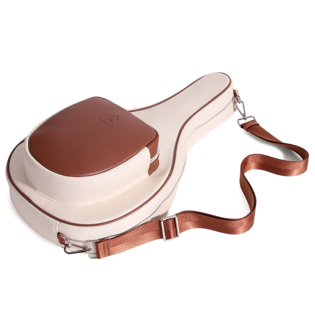 Side view of cream padel bag featuring brown leather top compartment