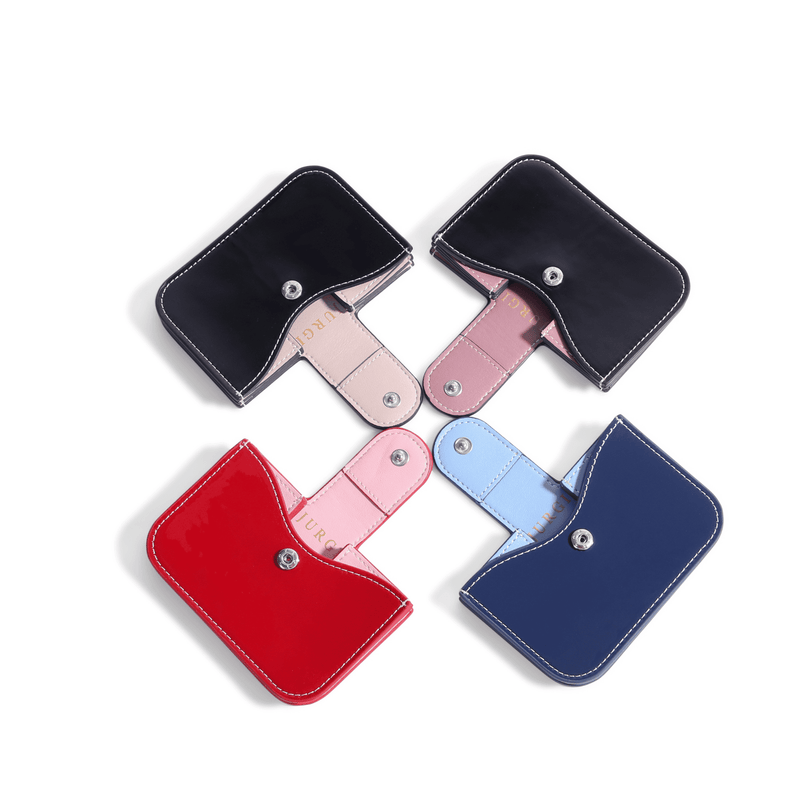 Four patent leather accordion wallets in red, navy, and two black, each with contrasting interior and silver snap closure.