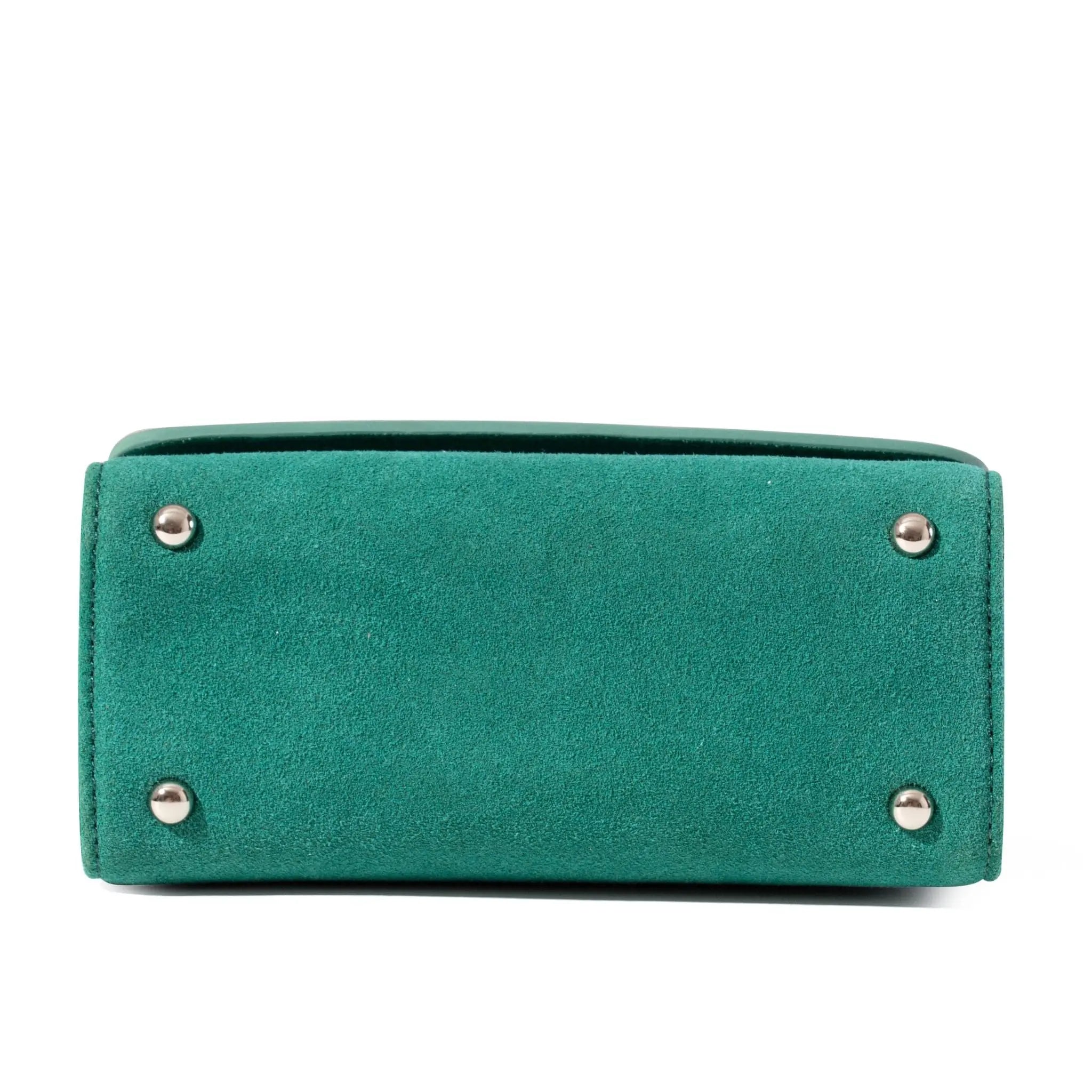 Mint clutch bag with silver studs on a white background, showing bottom support for suede