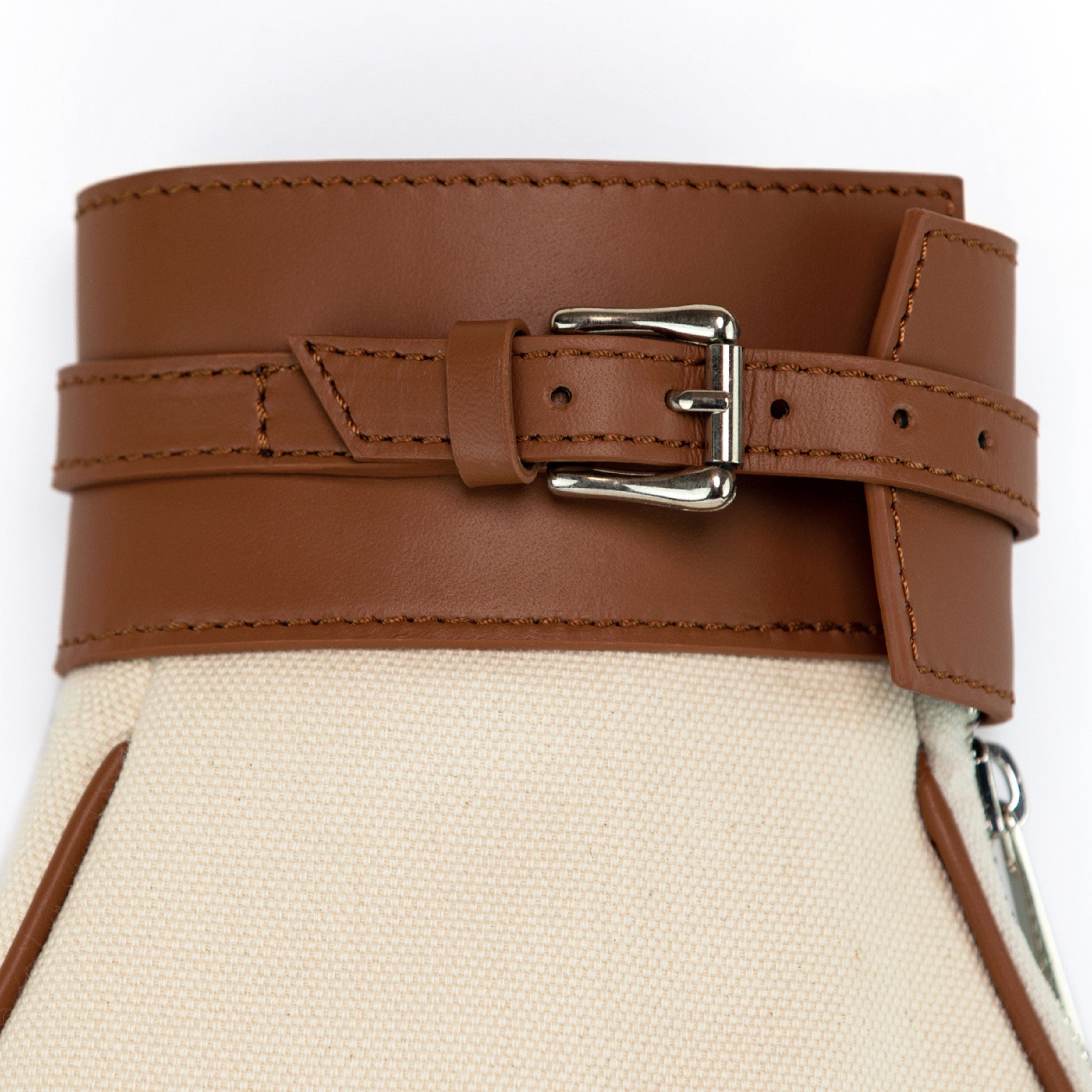Close-up of a brown leather belt with a metal buckle on a white background