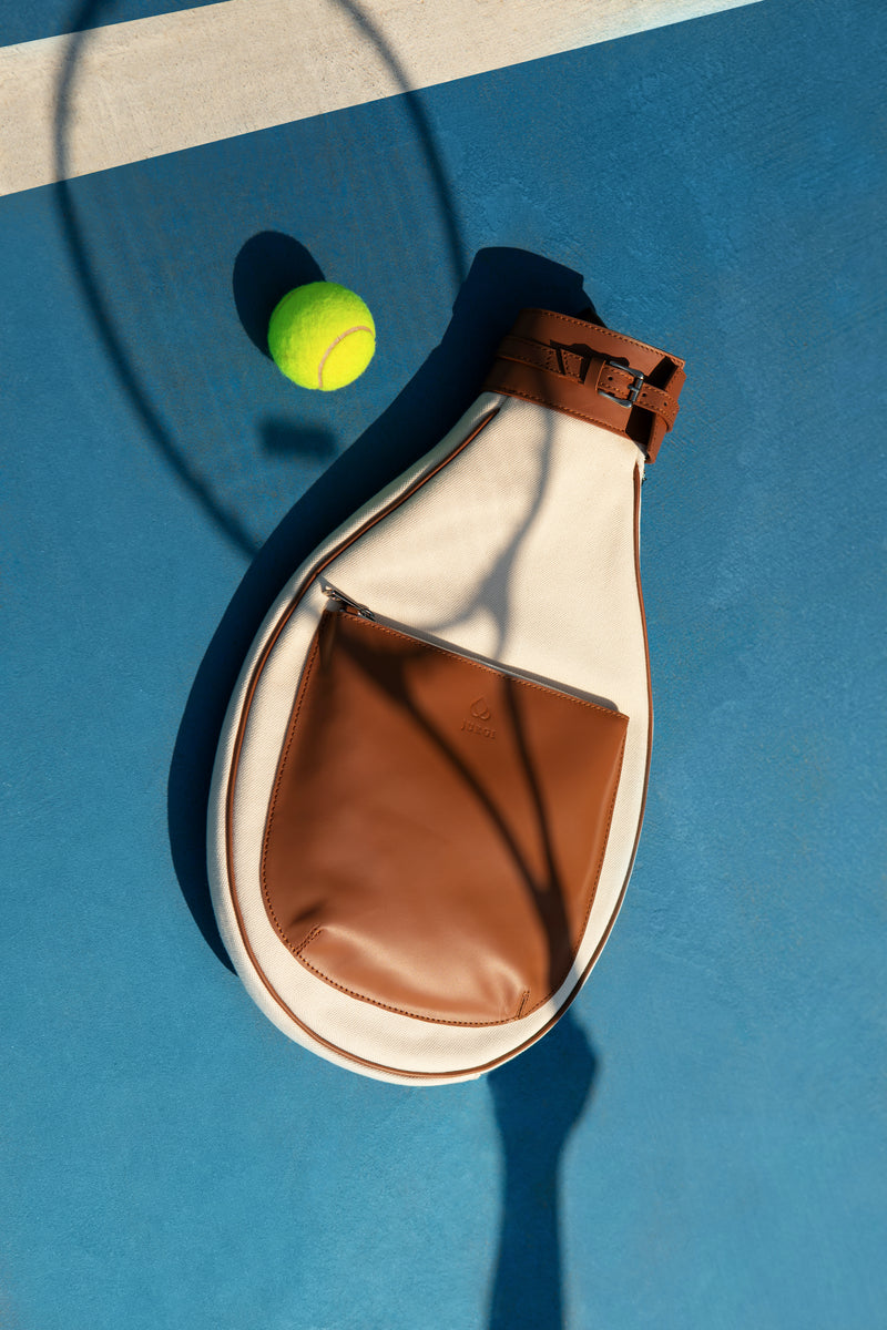 Beige canvas tennis racket bag with brown leather pocket