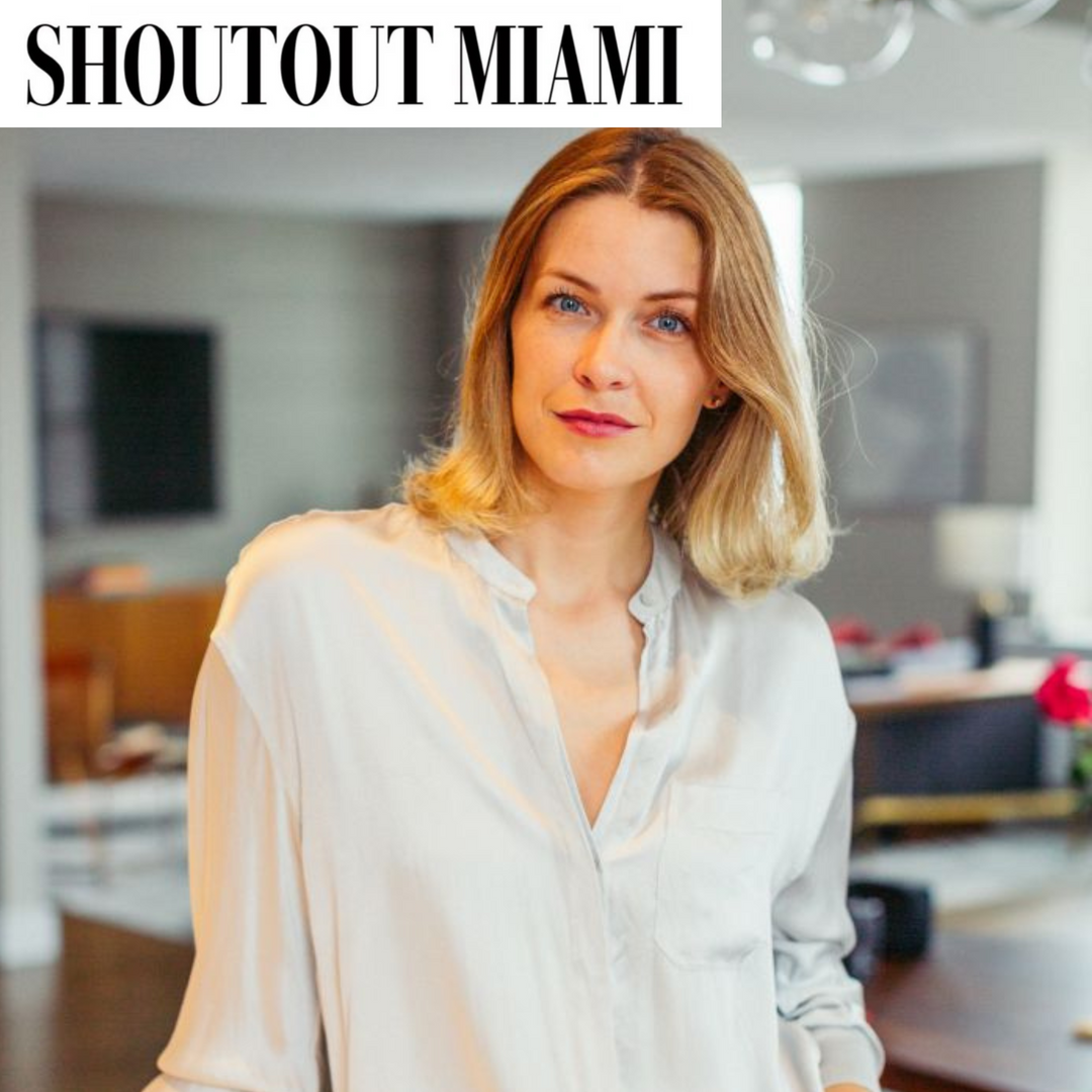 Woman in a white shirt standing in a modern kitchen with 'SHOUTOUT MIAMI' text at the top.